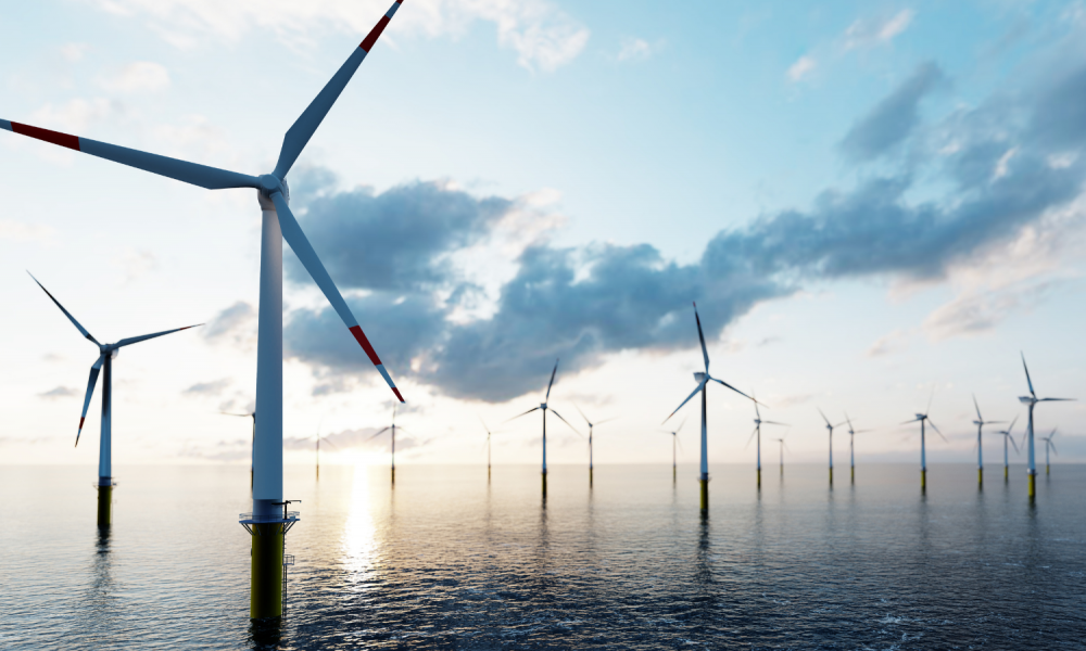 Offshore wind turbines against a blue sky and clouds