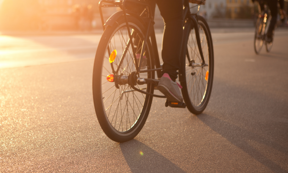 A person cycling down a road.