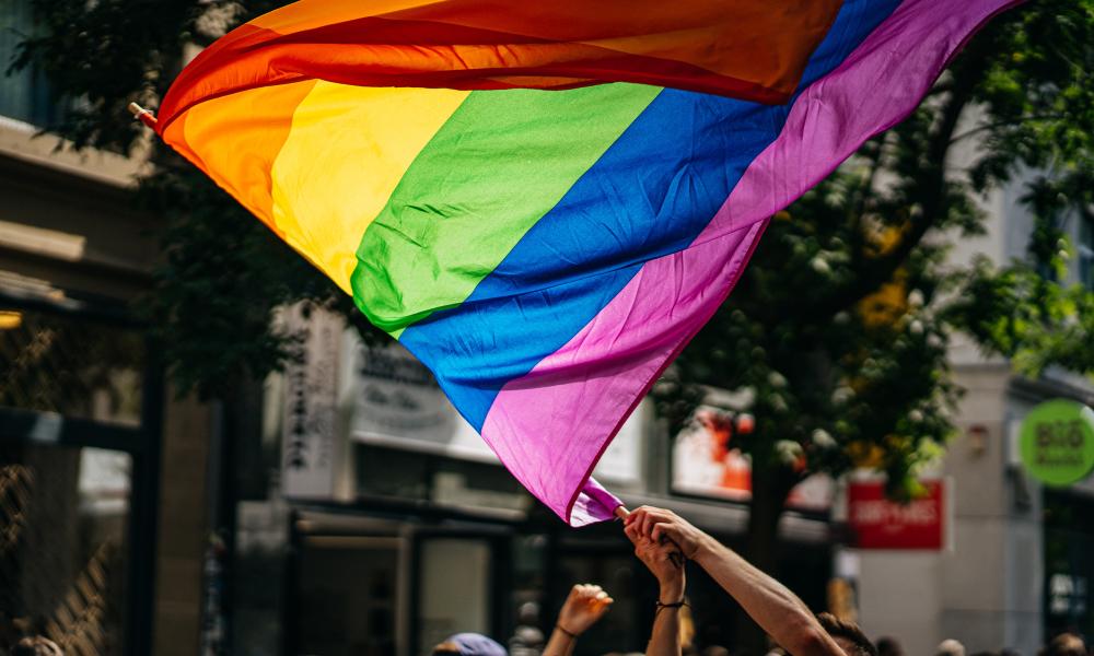 Pride flag being waved at a parade