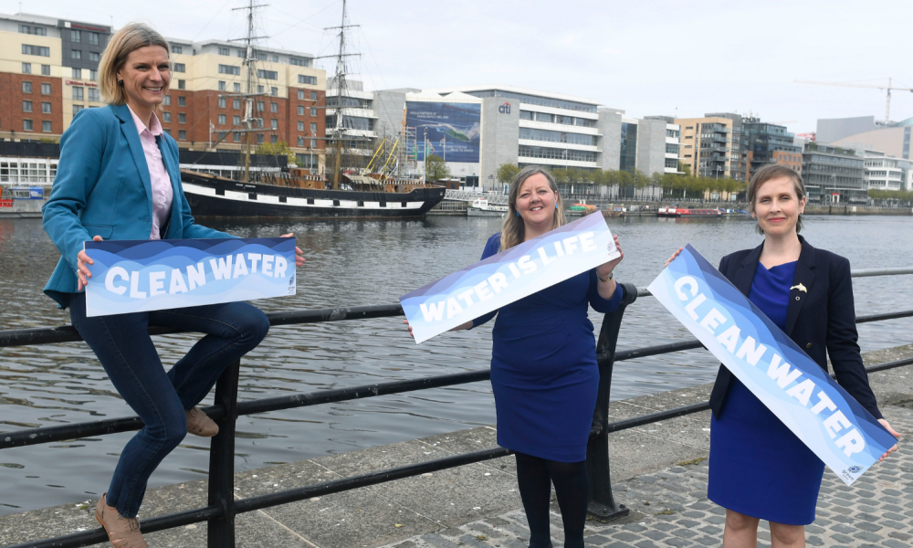 Senators Róisín Garvey, Pauline O'Reilly and Pippa Hackett hold signs reading "Water is Life" at the Liffey, Dublin.