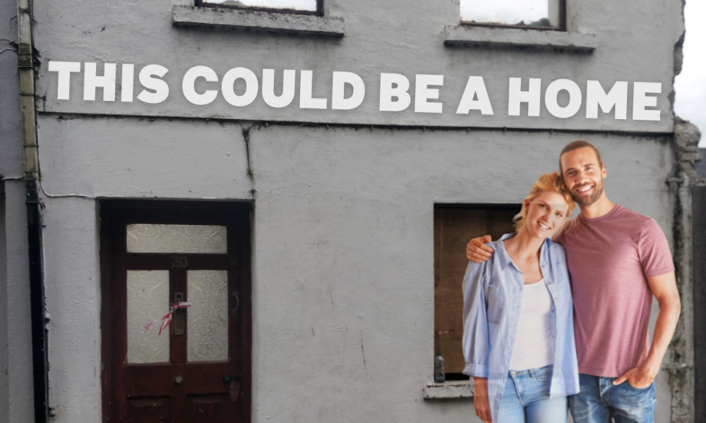 Young couple standing outside a vacant house with the line 'This could be a home'