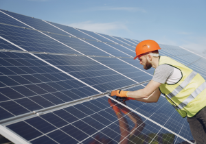 Solar technician installs panels on a roof