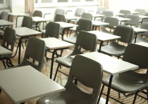 Empty classroom tables and chairs